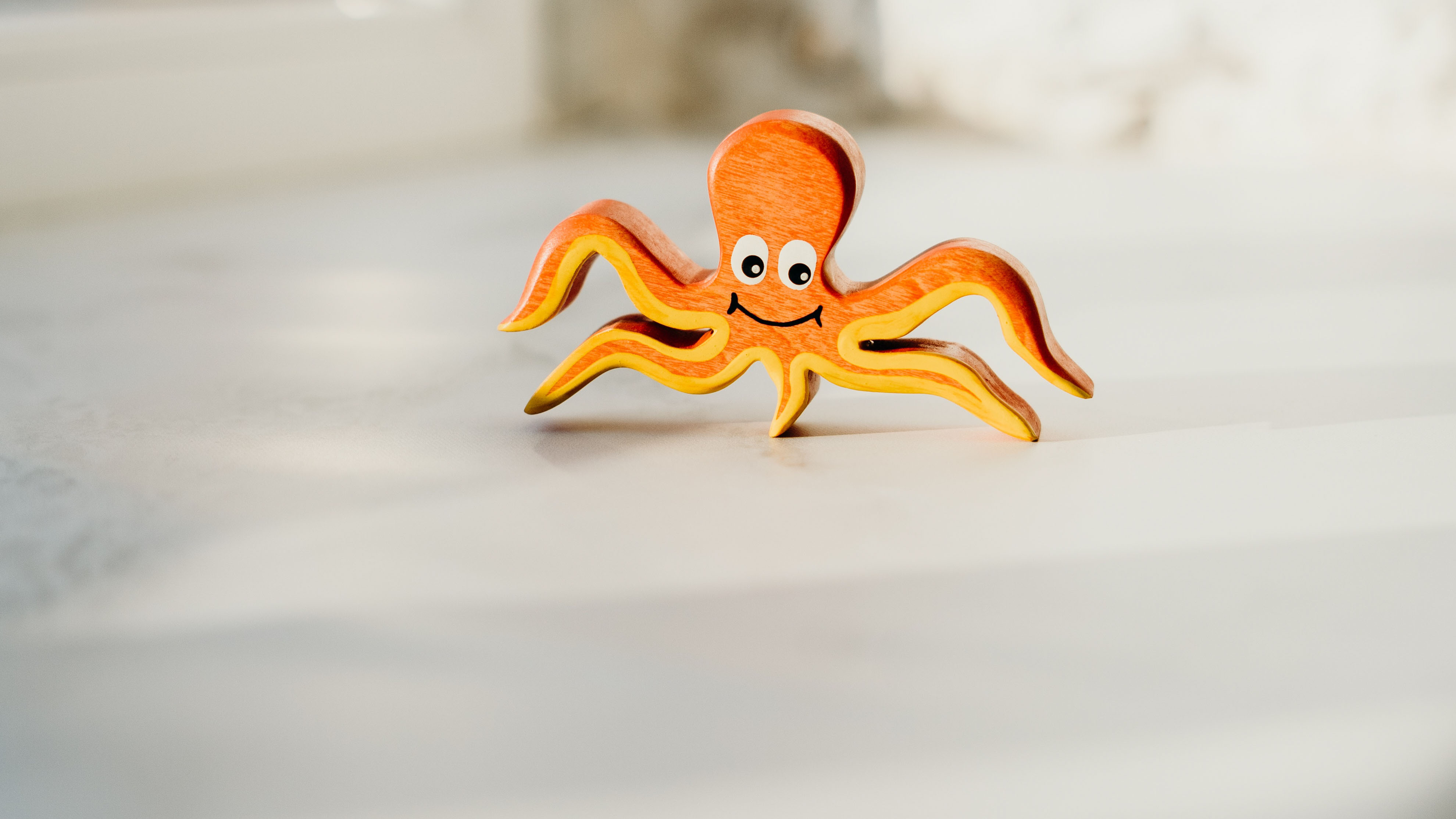 Orange octopus toy with smiling cartoon face.